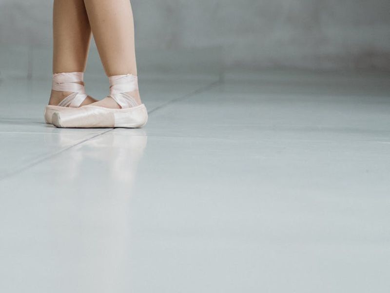 Person performing smooth cardio movements in a dark studio setting.